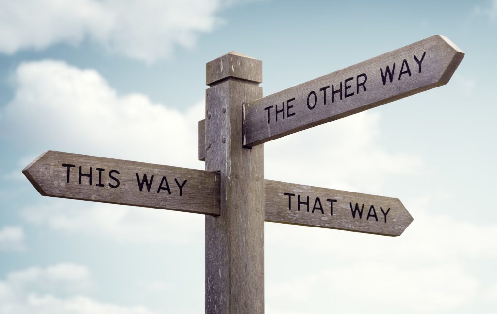 Crossroad signpost saying this way, that way, the other way 