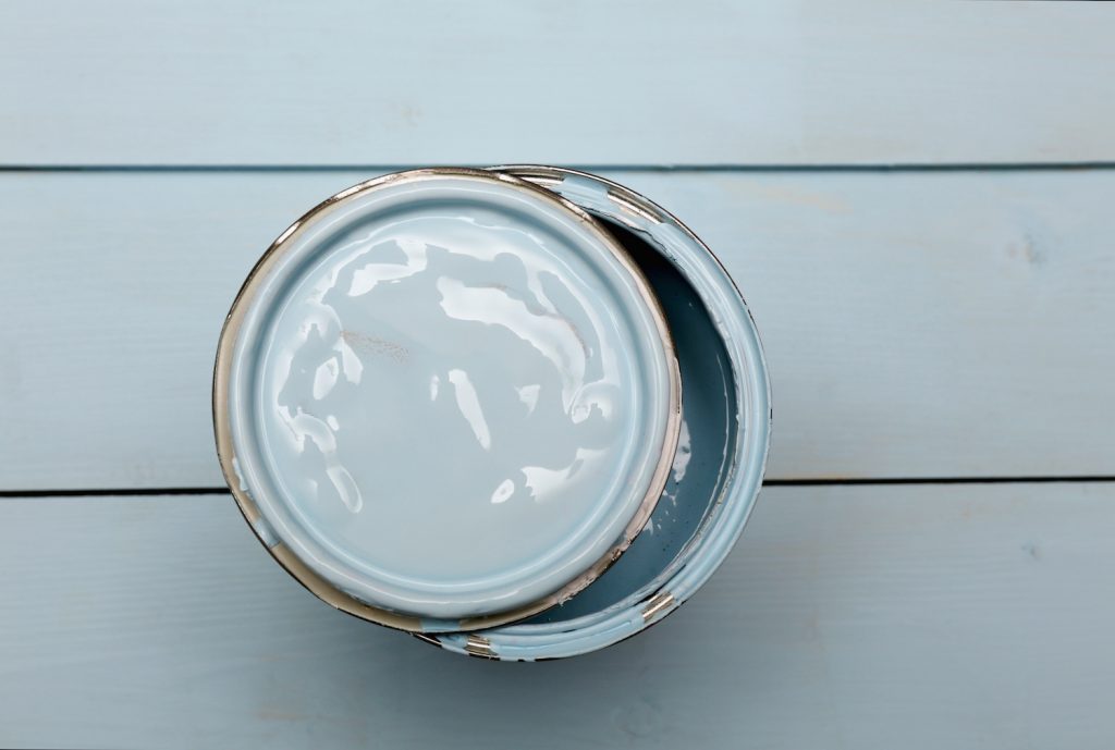open can of paint on a wooden background